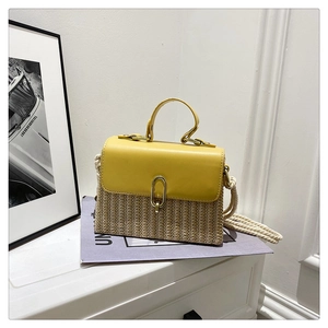 Detail of yellow woven straw crossbody bag with leather flap and metallic clasp