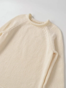 Nahaufnahme von beigem Strickpullover mit Rundhalsausschnitt und weicher Textur