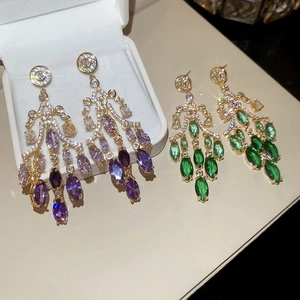 Detail von 18K vergoldeten Ohrhängern mit lila und grünen Zirkonia im Farbverlauf