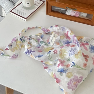 Close-up of lightweight floral mesh tote bag with colorful flower patterns on a desk