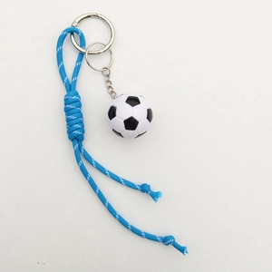Detailed macro view of woven blue and white nylon cord with soccer ball keychain pendant