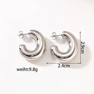 Detailed close-up of polished silver hollow C-shaped hoop earrings with butterfly backs
