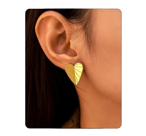 Close-up of heart-shaped gold leaf texture earrings on model for a trendy look