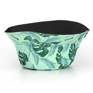 Détail d'un bob réversible avec imprimé feuilles de palmier et doublure noire