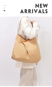 Detailed macro view of woven straw texture with brown leather strap and gold clasp on tote bag