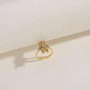Macro detail of a golden teddy bear ring featuring colorful zircon gemstone settings