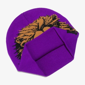 Detail of purple knitted beanie featuring a bold yellow and black lion graphic pattern