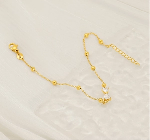 Close-up of gold stainless steel bracelet with heart zircon stones and lobster clasp