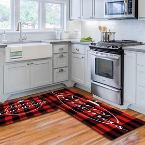 Detail of red and black buffalo plaid Christmas kitchen rugs set with holiday greetings