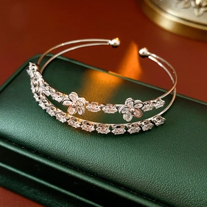 Détail macro d'un bracelet ouvert double couche avec fleurs en zircon et pierres marquises