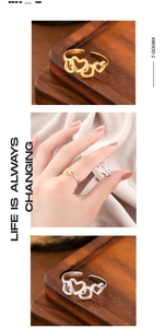 Detailed views of adjustable gold and silver heart rings on wood and silk display