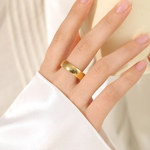 Minimalist wide band stainless steel ring in gold finish worn on finger for fashion