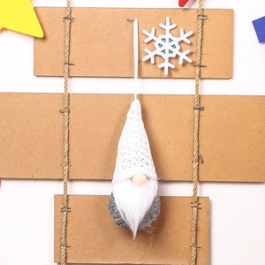 White knitted Christmas gnome hanging ornament with faux fur beard on wooden decor