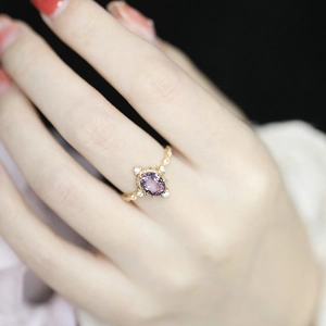 French vintage ring with oval purple amethyst and gold setting on female hand