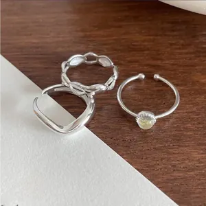 Detailed close-up of 925 silver rings with chain textures and gemstone details