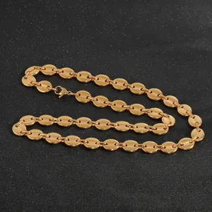 Collier chaîne grain de café doré en acier titane sur un élégant fond noir mat