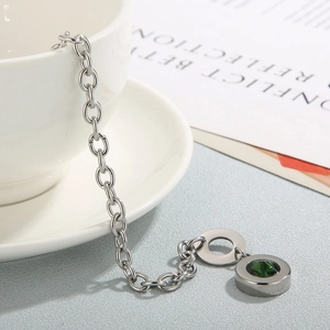 Close-up of a silver stainless steel OT buckle bracelet with a dark green crystal stone