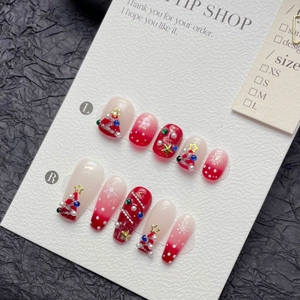 Handcrafted Christmas press-on nails featuring red gradient with stars and snowflakes