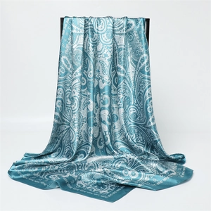 Détail d'un foulard en satin bleu sarcelle avec un motif cachemire argenté chic