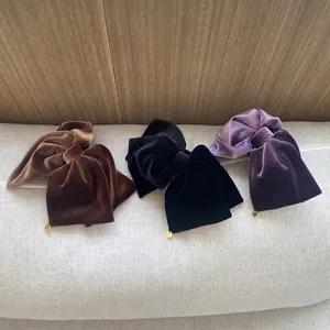 Set mit drei Samt-Haarklammern in Lila, Schwarz und Braun mit goldenen Anhängern