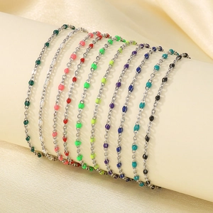 Detailed row of colorful resin beads on stainless steel chain anklets on silk