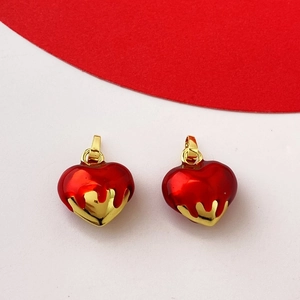 Detailed view of red enamel and gold heart pendants for romantic jewelry making