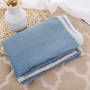 Detail of blue double-layer cotton baby blanket with delicate white lace embroidery edges
