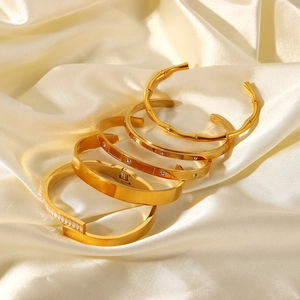 Ensemble de quatre bracelets en acier inoxydable plaqué or 18 carats avec zircons
