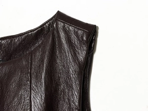 Dettaglio della texture in ecopelle marrone scuro con finitura a grana fine
