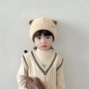 Detail of baby beige bear-ear knit hat with soft fleece lining and handmade label
