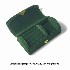 Detail view of emerald green velvet jewelry box with ring slots and gold clasp