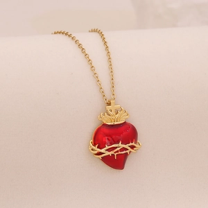 Golden necklace with a red enamel sacred heart pendant featuring cross and thorn details