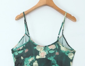 Dettaglio dell'abito sottoveste in raso verde con rose rosa e spalline sottili