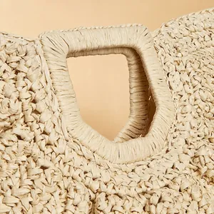 Handcrafted straw moon bag with woven handles and textured light beige paper fiber