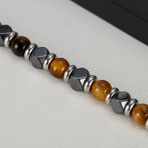 Makroaufnahme von Tigerauge- und Hämatitperlen mit silbernen Distanzstücken am Armband