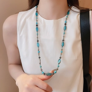 Détail du collier de perles en pierre bleue avec entretoises métalliques sur mannequin