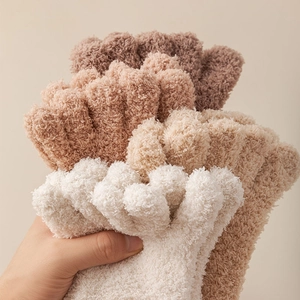 Close-up of thick fuzzy five-finger coral fleece socks in soft earth tones for winter