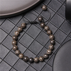 Macro view of woven braided tiger eye stone bead bracelet with adjustable cord strap