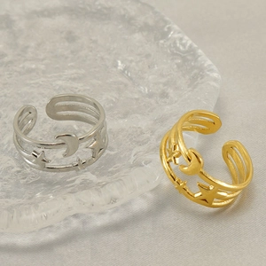 Star and moon镂空 open rings in gold and silver finish displayed on glass plate