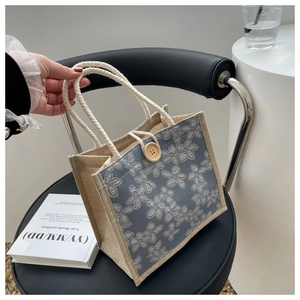 Detailed shot of a floral canvas lunch bag with cotton rope handles and wood button closure