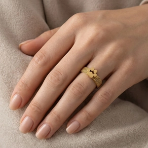 Macro shot of gold mesh band ring featuring a hollow cat paw design on finger