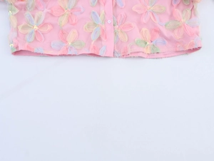 Detail of pink mesh hem featuring 3D colorful flowers and shiny sequin accents