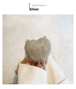 Detail of silver heart-shaped evening bag with crystal rhinestones and metal chain