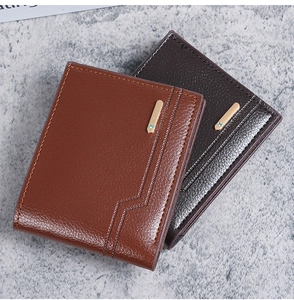 Detail of short leather wallets showing brown litchi texture and gold metal accents