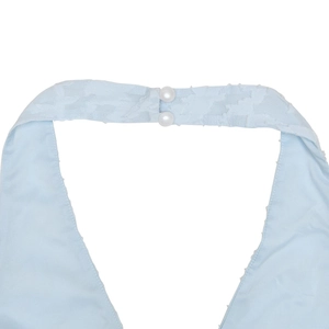 Close-up of light blue halter neckline with textured jacquard fabric and pearl buttons