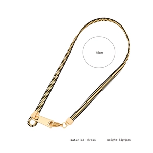 Detail view of gold and black zipper necklace with brass material and size specifications