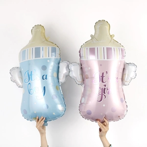 Detail of baby bottle foil balloons with wings for gender reveal party decoration