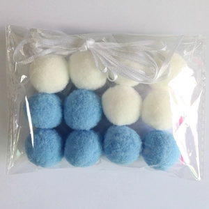 Detail of blue and white plush balls in a clear bag with ribbon for party DIY decoration