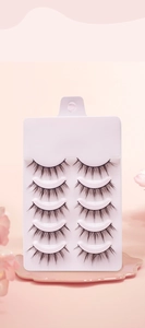 Close-up of five pairs of natural long black false eyelashes on a white tray with cherry blossoms