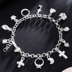 Detailed view of silver charm bracelet with heart, star, and cross on black background